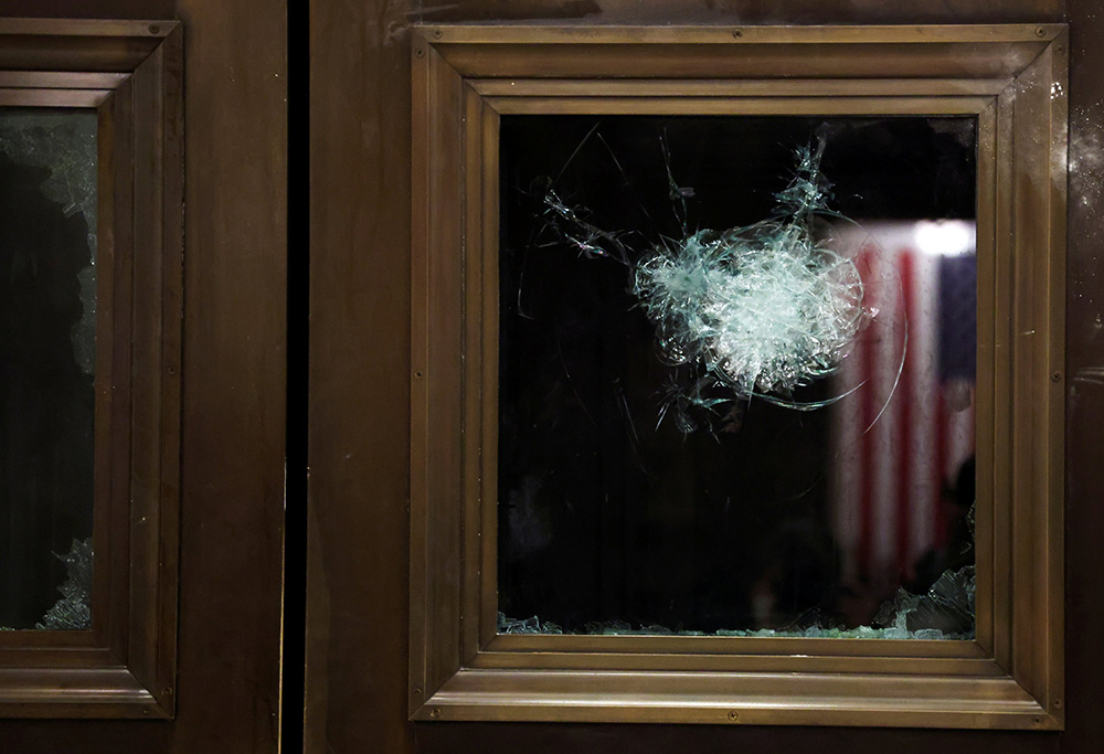A broken window is seen in the U.S. Capitol during a joint session of Congress in Washington Jan. 7 after lawmakers reconvened to certify the Electoral College votes of the 2020 presidential election. (CNS/Reuters/Jonathan Ernst)