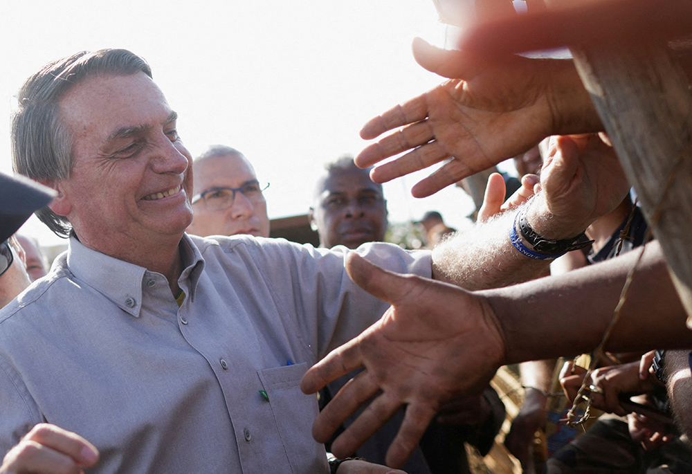 President Jair Bolsonaro greets supporters during an election campaign at a settlement of rural workers Oct. 24 in Brasilia, Brazil. (CNS/Reuters/Adriano Machado)