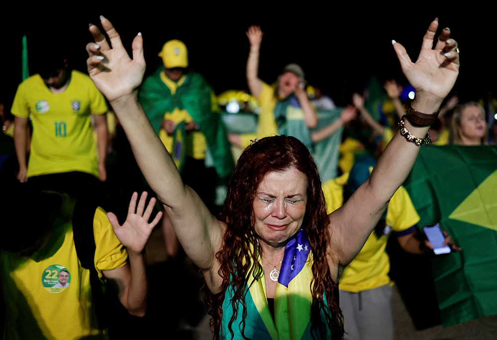 A supporter of Brazil's president and presidential candidate, Jair Bolsonaro, cries after former President Luiz Inácio Lula da Silva was proclaimed the winner of the presidential runoff, Oct. 30 in Brasilia, Brazil. (CNS/Reuters/Ueslei Marcelino)