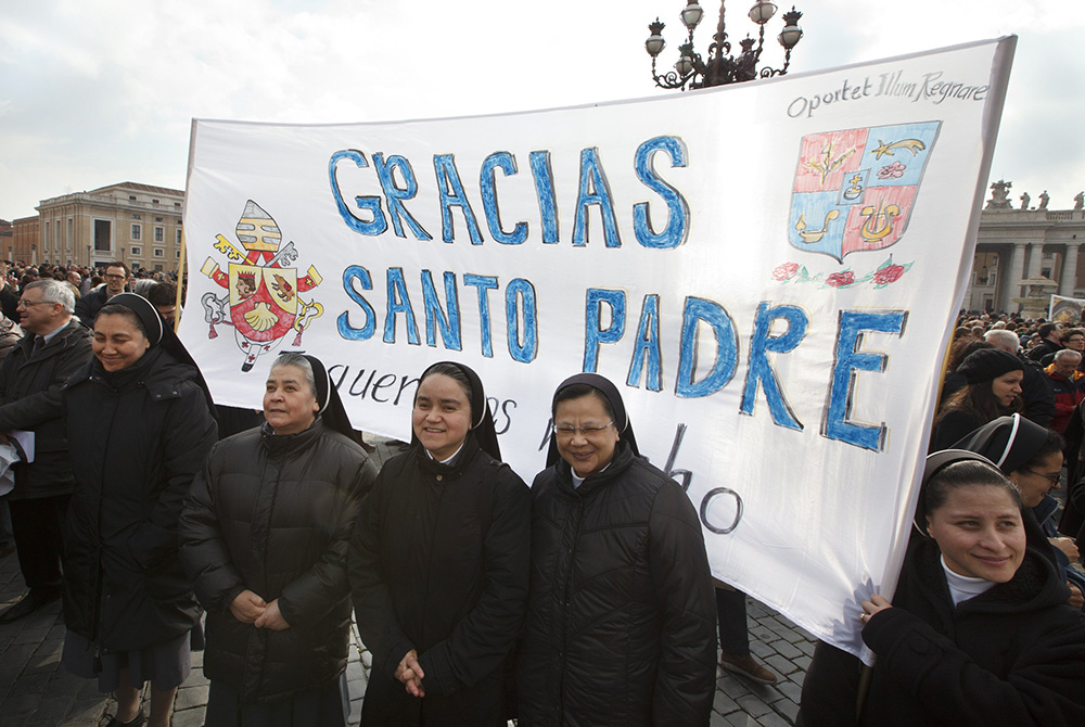 Nuns hold a banner thanking Pope Benedict XVI before he delivers the Angelus from the window of his apartment overlooking St. Peter's Square at the Vatican on Feb. 17, 2013, a week after he had announced his resignation. (CNS/Paul Haring)