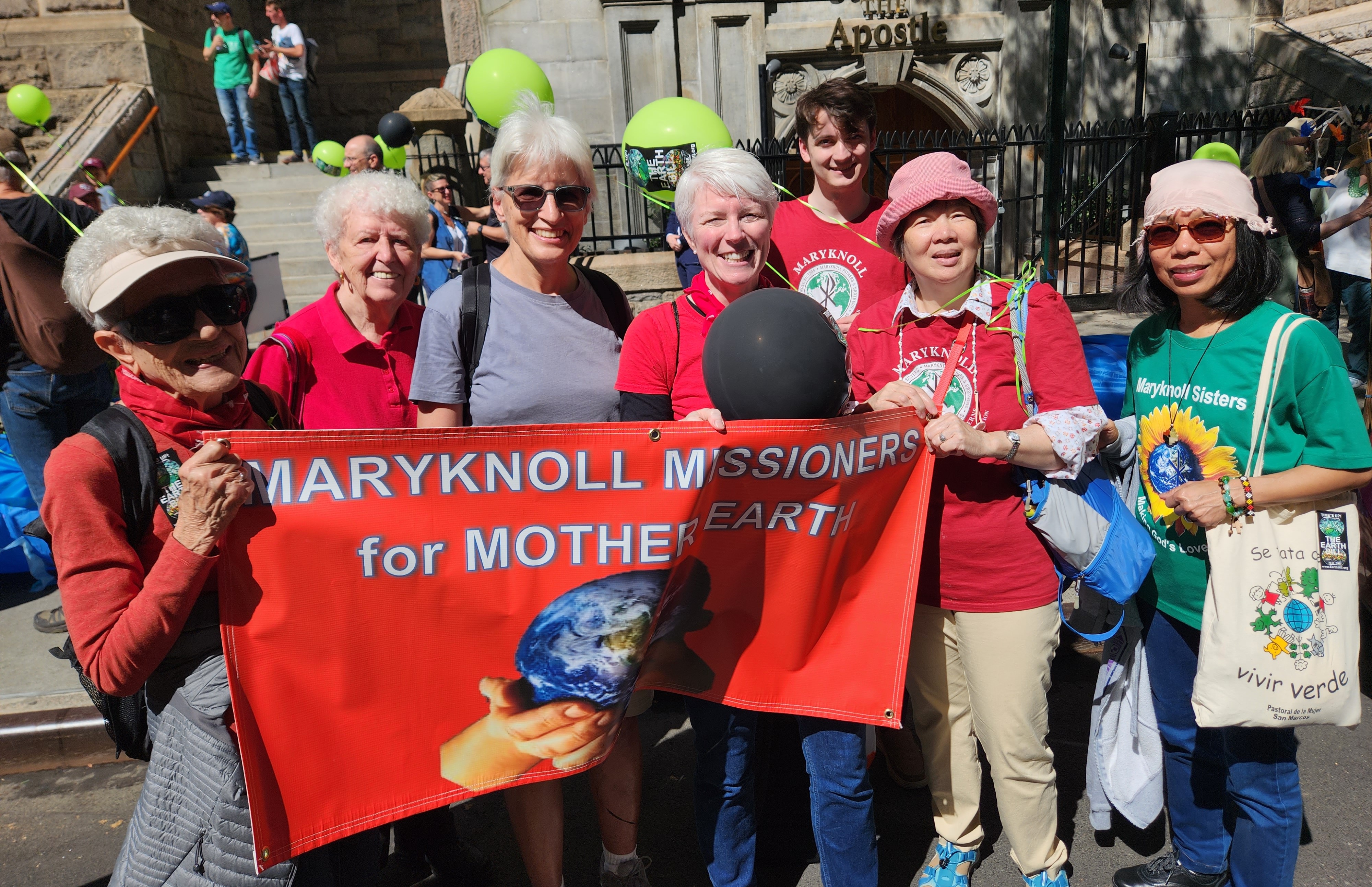 A group of people with banner for Maryknoll Missioners