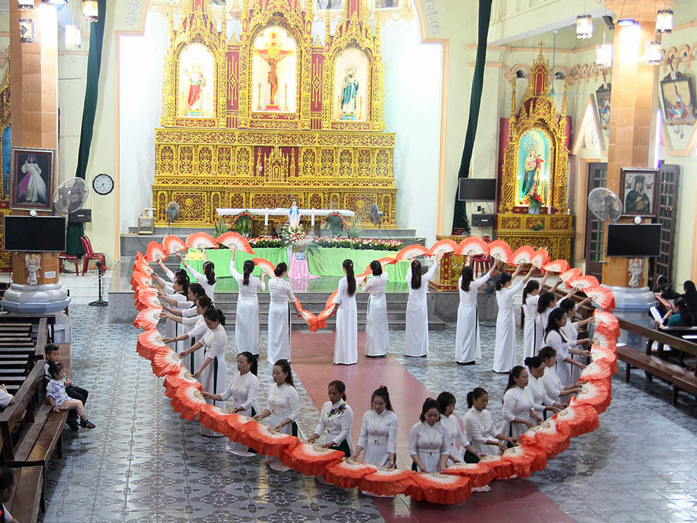 Twenty-eight women in white ao dai dance and form a heart of colorful fans in Yen Bai Church in Vietnam on Oct. 14. (GSR photo/Joachim Pham)