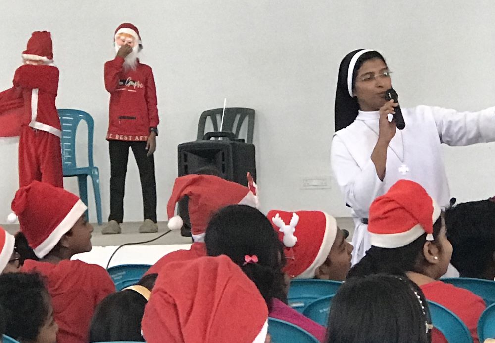 A Carmelite nun at St. Mary's Church, Alangad, near Ernakulam, leads a Christmas celebration for catechism students and their parents on Christmas Eve. (Thomas Scaria)
