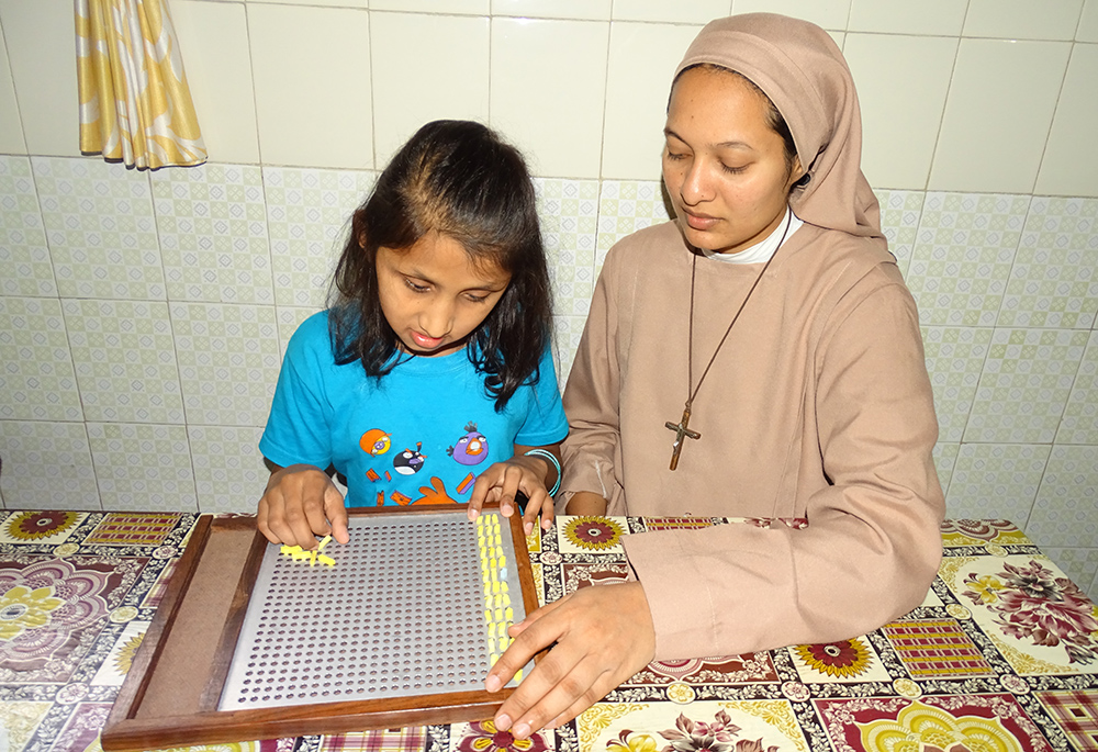 Franciscan Sisters Servants of the Cross Sr. Mary Juliana teaches mathematics to Theerthavathi, a student of the Jyothi Seva School, Bengaluru, southern India. (Courtesy of Sr. Mary Clare)