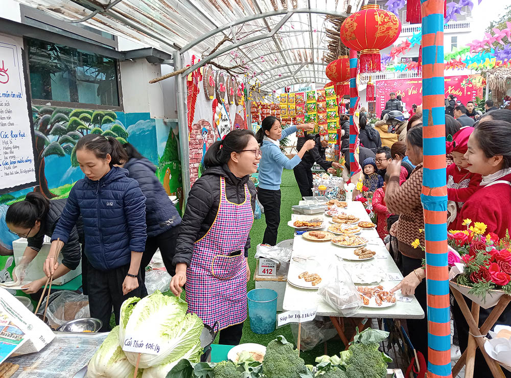 Lovers of the Holy Cross of Hung Hoa sisters serve food to visitors at the Tet fete. Sr. Mary Nguyen Thi Thu (wearing an apron) said, "We sell quality food at very low prices so that all people can enjoy the Tet festivities." (Joachim Pham)