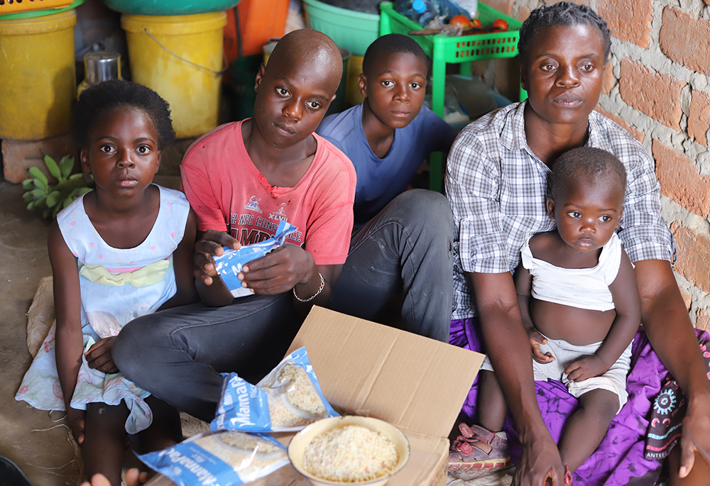 Ella Daura, 41, shares the food she received from religious sisters with her children at her home in Chibombo, a town in the central region of Zambia, on March 11. (Doreen Ajiambo)