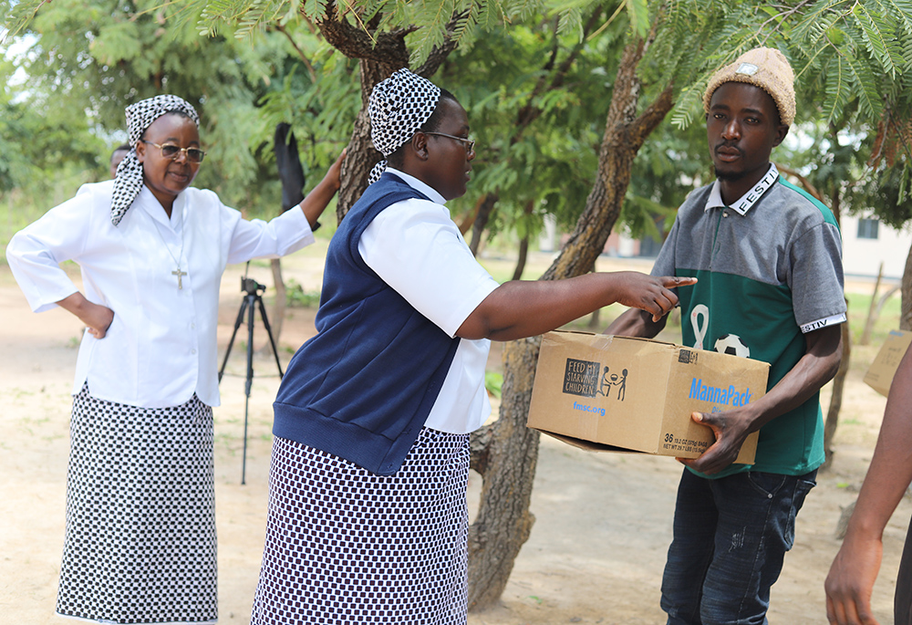 Sr. Christine Mubanga donates a food box to a Chibombo resident in the central region of Zambia on March 11. (Doreen Ajiambo)