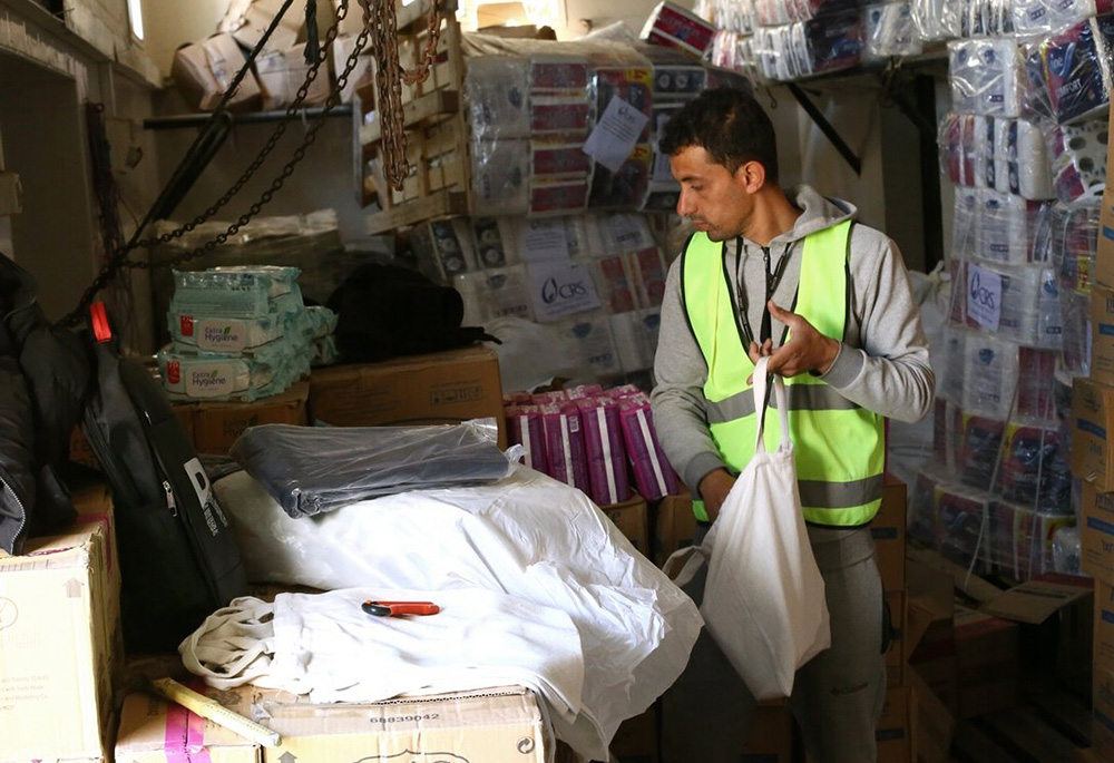 A humanitarian aid worker packs Catholic Relief Services relief supplies in Rafah, in the southern Gaza Strip, for distribution to people displaced in war-torn Gaza. (OSV News/Mohammad Al Hout for CRS)