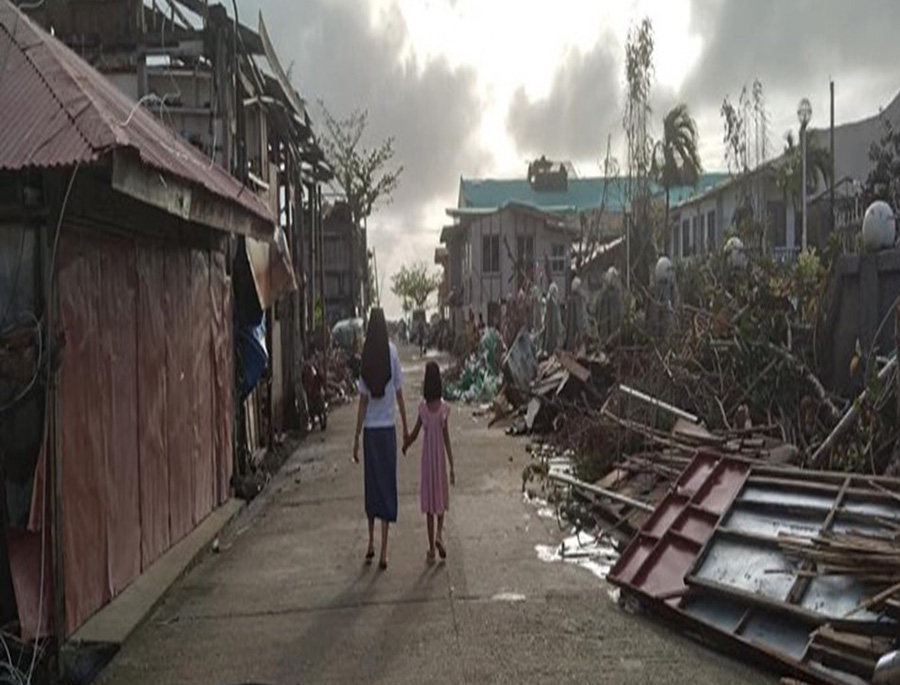 An Missionary Sister of Mary sister walks with her niece to see the aftermath of the typhoon in her hometown in the Dinagat Islands, which were among the worst hit. (Courtesy of Missionary Sisters of Mary) 