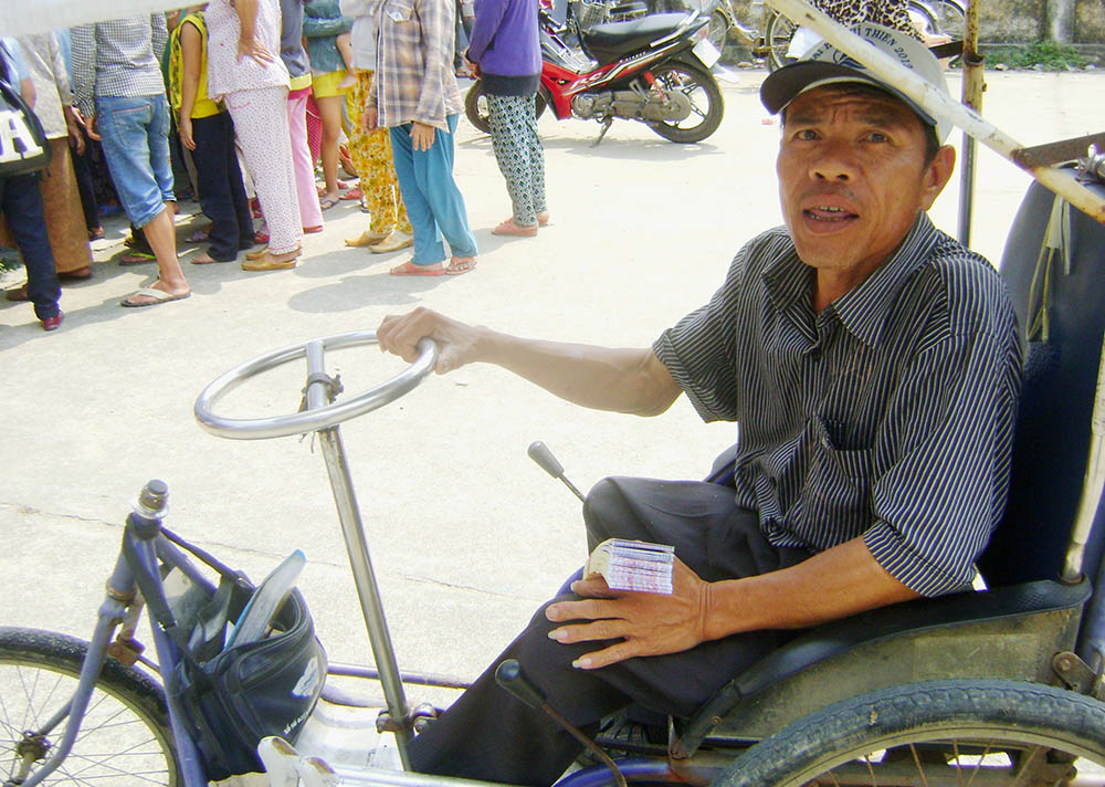 Truong Van Lenh vende billetes de lotería en su triciclo. 