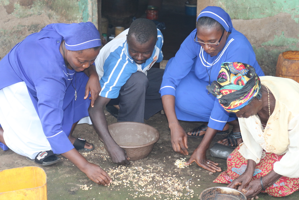 Las hermanas Ruphina Anosike, a la izquierda, y Monica Yahaya, segunda por la derecha, ayudan a clasificar los granos que habían sido derramados en el mercado por mujeres acusadas de brujería en Ghana. Estas mujeres también sobreviven recogiendo leña, vendiendo pequeñas bolsas de cacahuates (maní) o trabajando en las granjas cercanas. (Foto: Doreen Ajiambo)