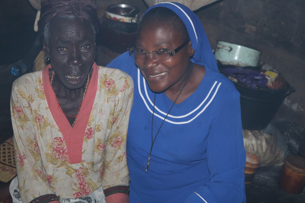 La Hna. Mónica Yahaya, a la derecha, con una anciana que vive en el campamento de Gushegu porque fue acusada de brujería. (Foto: Doreen Ajiambo)