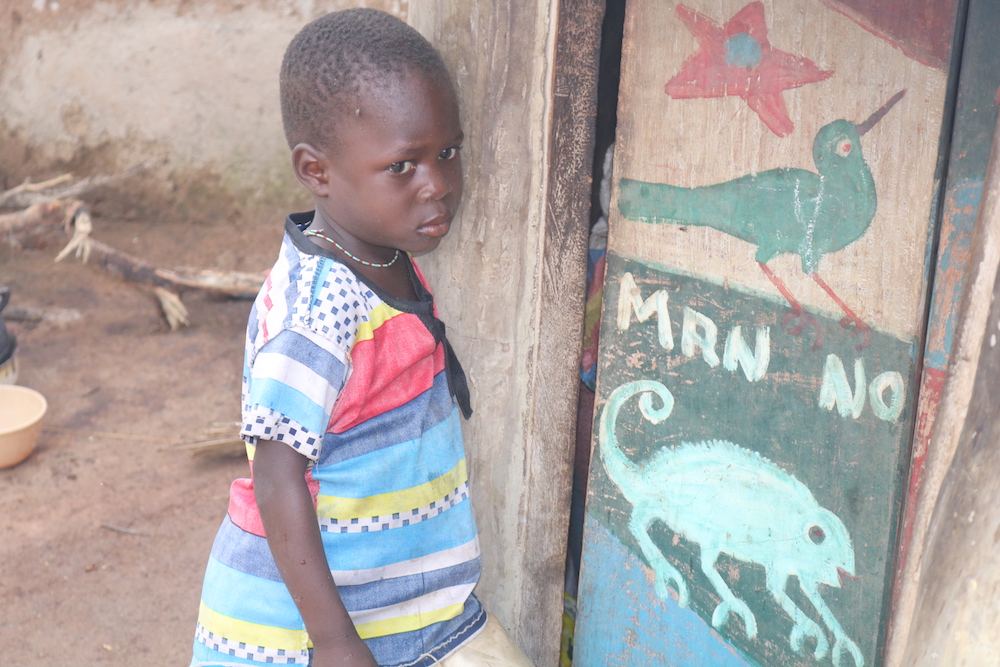 Una niña frente a la cabaña de su madre en el campamento de Gushegu. Su madre fue acusada de matar a su marido. (Foto: Doreen Ajiambo)