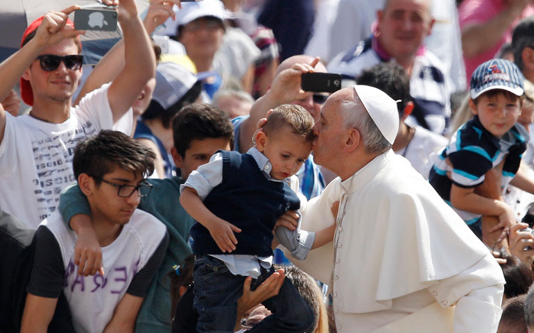Pope Francis kisses a boy as he arrives for his weekly general audience in St. Peter’s Square at the Vatican June 5. (CNS/Paul Haring)