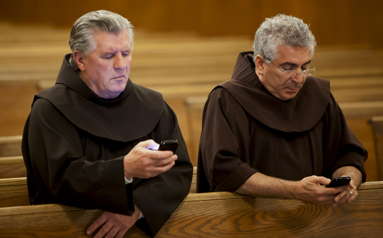 Franciscan Brs. Richard Mcfeely and Robert Frazzetta read prayer requests on their mobile phones Jan. 3 at St. Anthony Friary in Butler, N.J. (CNS/Octavio Duran)