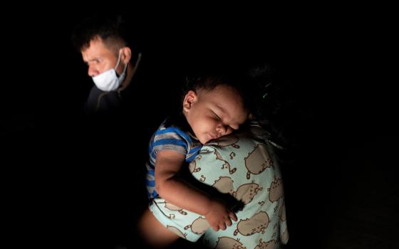 A migrant child from Central America sleeps on his mother's shoulder in Roma, Texas, July 28, 2021, after they crossed the Rio Grande into the United States from Mexico seeking asylum. (CNS/Reuters/Go Nakamura)