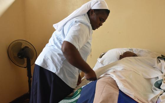 Sr. Adelina Adao, assistant administrator for Our Lady's Health Centre, attends to a patient during her routine work in one of the wards at the health center in Kalingalinga, one of the densely populated slums near Lusaka. (GSR photo/Derrick Silimina) 