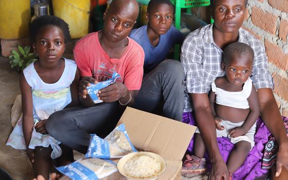 Ella Daura, 41, shares the food she received from religious sisters with her children at her home in Chibombo, a town in the central region of Zambia, on March 11. (Doreen Ajiambo)