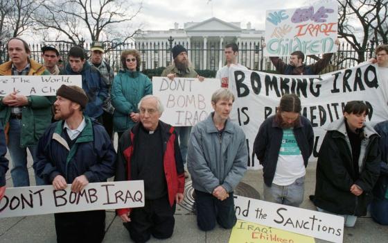 Detroit Auxiliary Bishop Thomas Gumbleton kneels with other demonstrators in front of the White House Feb. 12, 1998, to protest military strikes against Iraq. 
