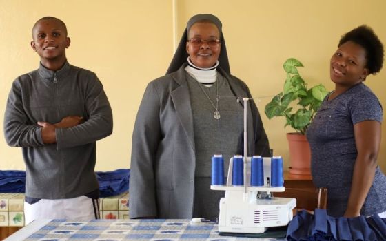 Sr. Victoria Mota, a member of Holy Family Sisters of Bordeaux-Lesotho, poses with students in the sewing room at the sewing center located at Holy Family High School in Leribe, Lesotho. (GSR photo/Doreen Ajiambo)              