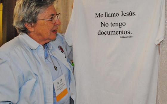 Daughter of Charity Sr. JT Dwyer displays a T-shirt hanging in the LCWR Region XII: Family Detention booth, one of the exhibitors at the assembly. In English on the other side, the shirt says: "My name is Jesus. I have no papers." (GSR photo/Dawn Cherie Araujo)