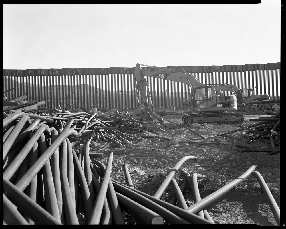 Outside Forrest, Arizona, in the last weeks of the Trump presidency, pieces of the old wall are thrown away as a new wall is built. (© Lisa Elmaleh)