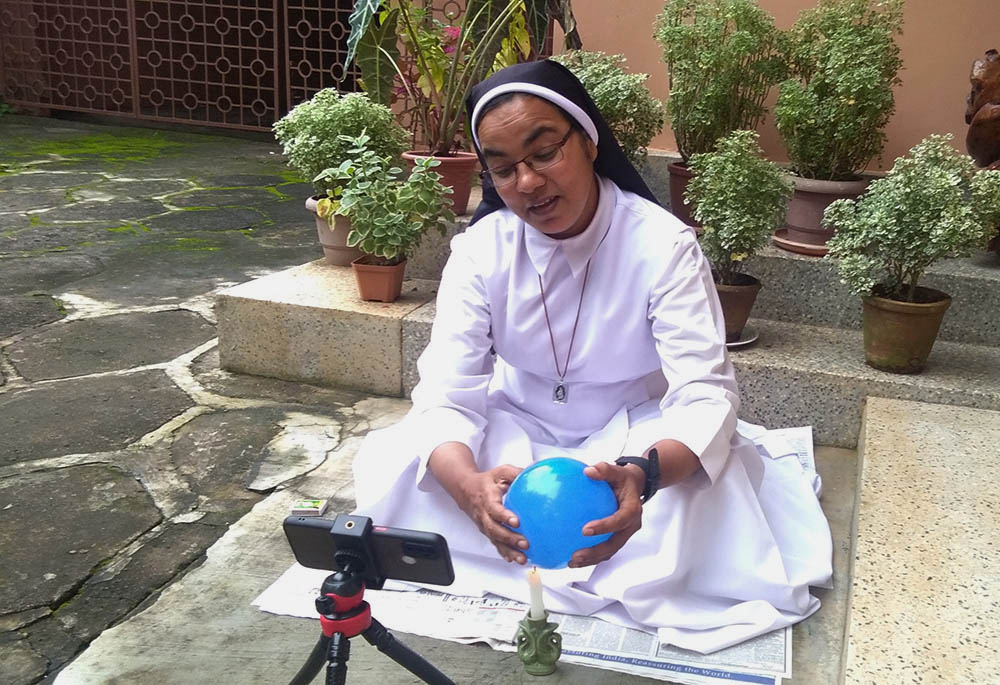 Sr. Sunitha Ruby, a member of the Congregation of Carmelite Religious, records a motivational video on her mobile using a balloon to make a point, at her convent in Thiruvananthapuram, capital of Kerala state, southwestern India. (Lissy Maruthanakuzhy)
