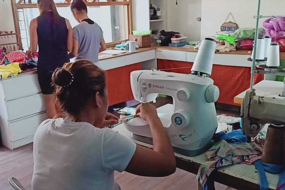 Girls at the School of Life make masks for workers at a nearby hospital