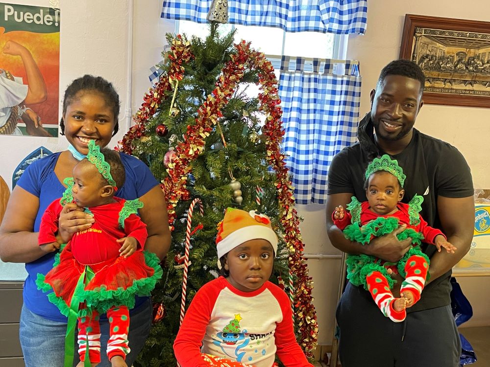 A refugee family from Haiti celebrates Christmas at a soup kitchen in Immokalee, Florida. The twins were born two weeks after the family arrived in the country. (Judy Dohner)