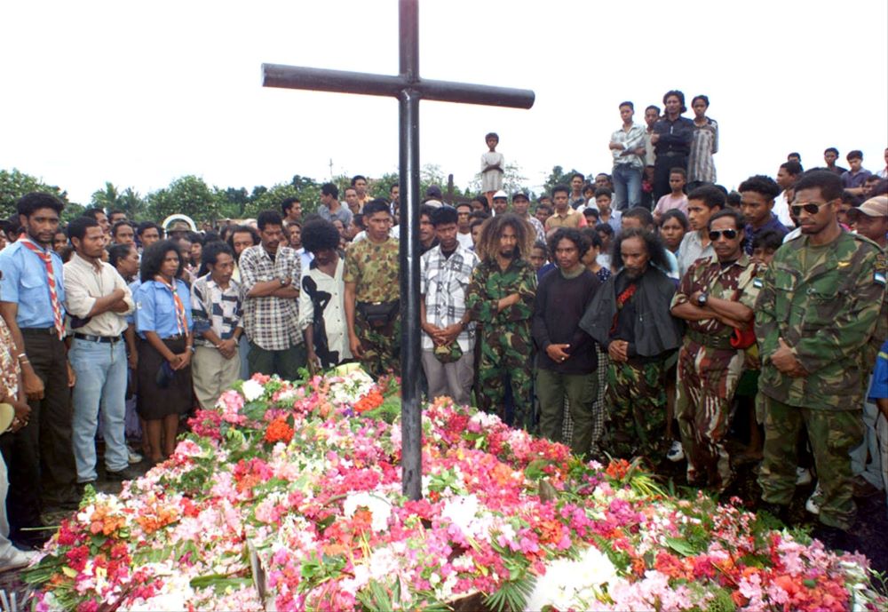 Timorese, including independence fighters in fatigues, gather Nov. 12, 1999, at the common grave of victims of a 1991 massacre in Dili, Timor-Leste. (CNS/Reuters)