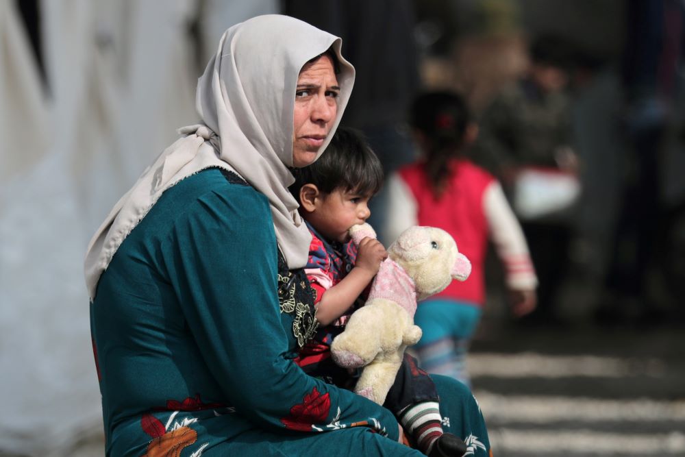 A woman holds a child at a makeshift camp in Azaz, Syria, on Feb. 14, 2020. Syria was ranked second to last (after Afghanistan) in the 2021/22 Women, Peace and Security Index, which documents progress for women worldwide. (CNS/Reuters/Khalil Ashawi)