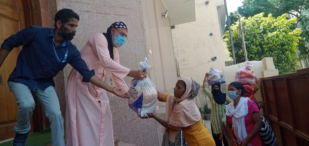 Bishop Jacob Mar Barnabas of the Gurgaon Syro-Malankara diocese, second from left, distributes food kits to those who need them during the coronavirus lockdown. (Courtesy of Fr. Nijo Kollentethekkethil)