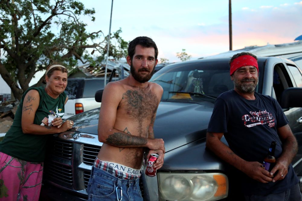 From left, Nora Rodrigue, her son, Brent Rodrigue Jr., and Glynn Chaisson lean on a truck where they are now sleeping after their homes were destroyed by Hurricane Ida in Chauvin, La. (AP/Jessie Wardarski)