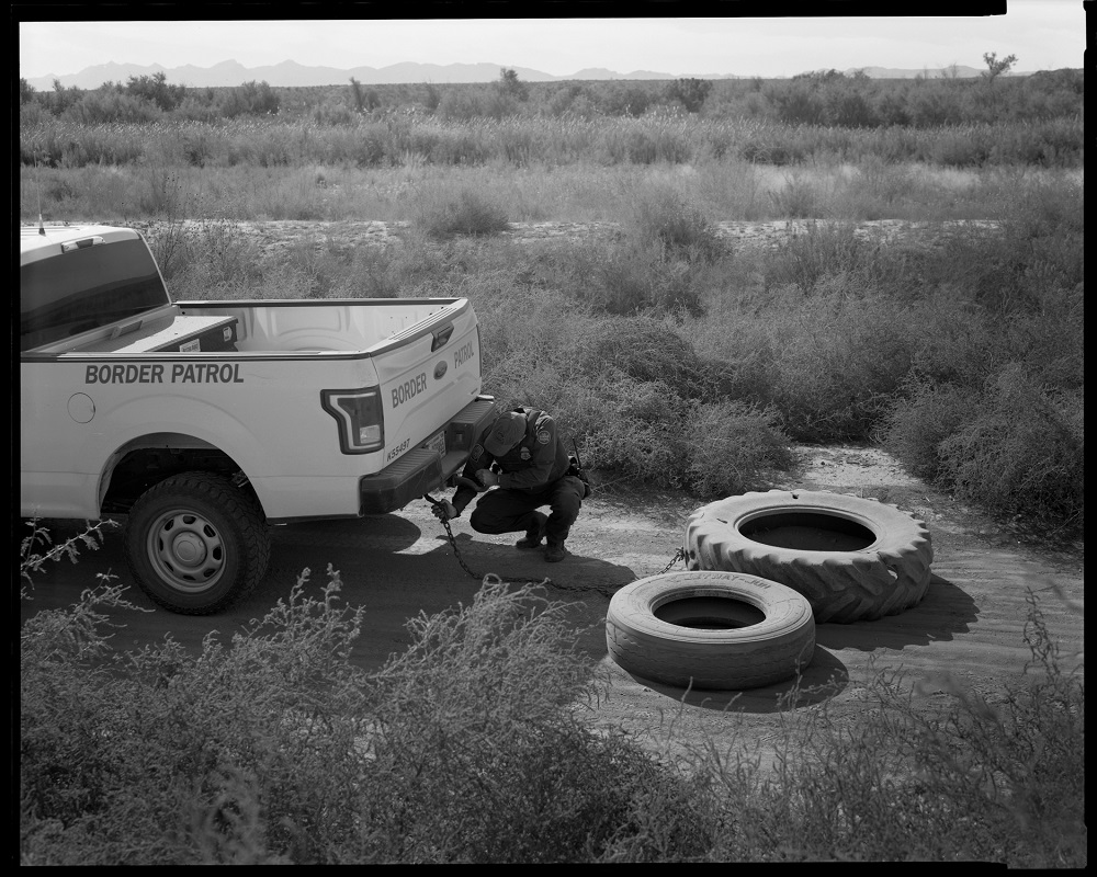 A Border Patrol agent in Texas drags tires behind his truck in June 2020 to smooth the dirt road in a stretch of land with no wall so footprints are more visible. Drug traffickers, which he says are common in that area because of a nearby interstate, were