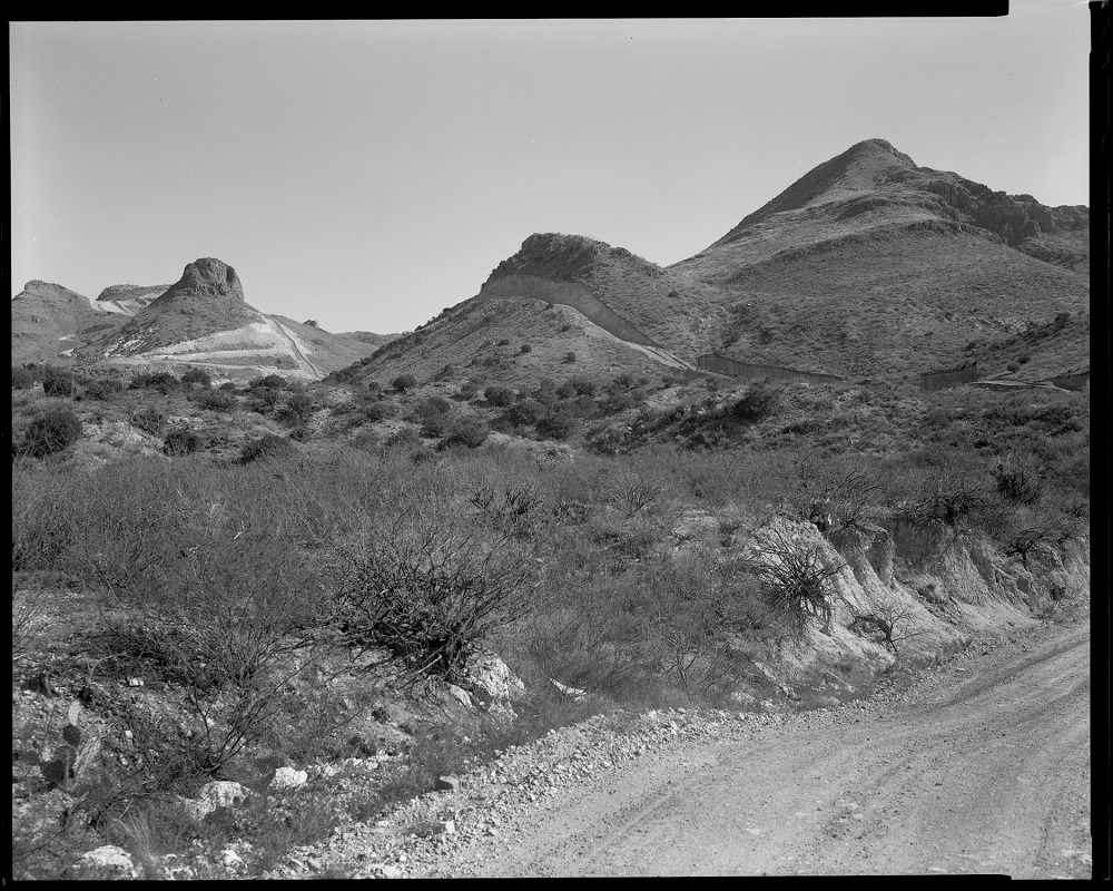 A portion of unfinished border wall is faintly visible at right against Guadalupe Canyon in Arizona, where a section of the landscape was intentionally cut down for wall construction. This photo was taken shortly before President Joe Biden's inauguration,