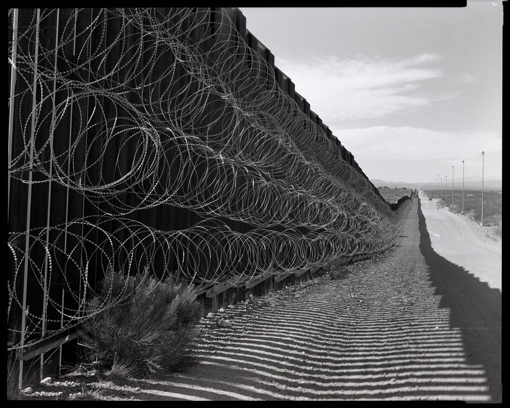 The border wall in Douglas, Arizona, in October 2020. The barbed wire is a typical feature on parts of the wall that border two cities, such as this one straddling Douglas and Agua Prieta, Mexico. (© Lisa Elmaleh)