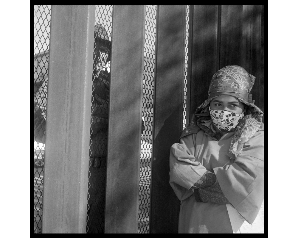 A woman on the Mexican side and a man on the American side meet at the fence to talk during the Las Posadas observation in December 2021. In addition to the religious gathering, migrants walked along the border wall singing songs in protest of Title 42 an