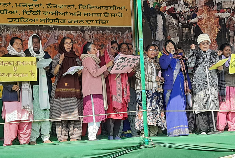 Presentation Sr. Dorothy Fernandes (at far right in white cap) and Catholic nuns offer a song of support to farmers protesting on the border of the Indian capital. (Courtesy of Dorothy Fernandes) Presentation Sr. Dorothy Fernandes (at far right in white cap) and Catholic nuns offer a song of support to farmers protesting on the border of the Indian capital. (Courtesy of Dorothy Fernandes)