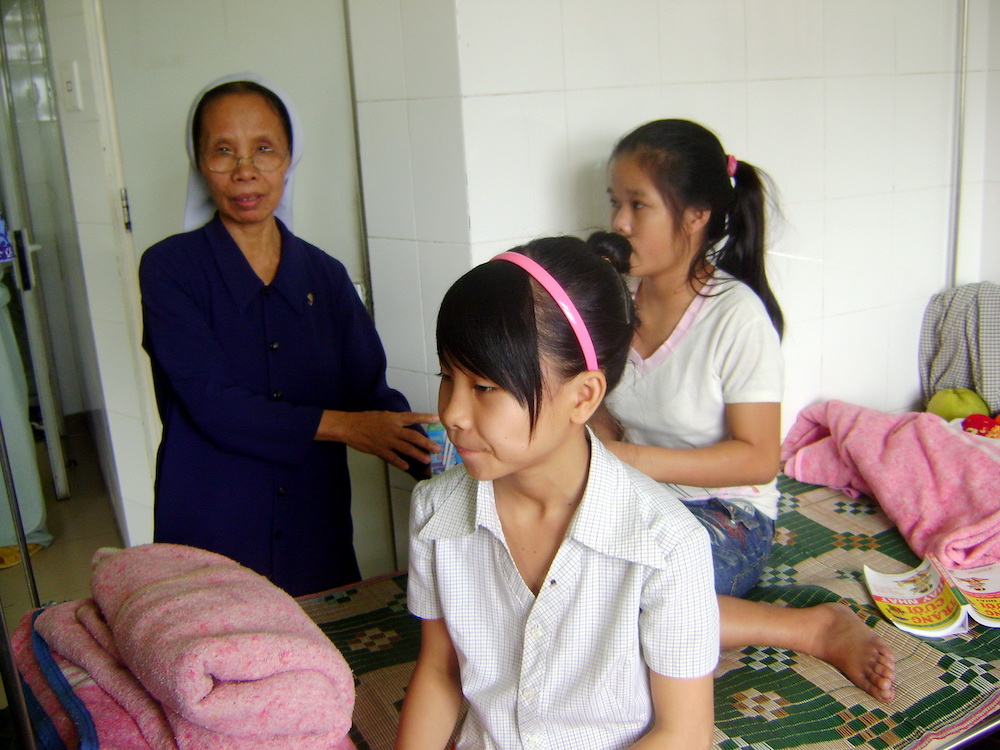 Daughters of Our Lady of the Visitation Sr. Lucia Nguyen Thi Nong offers milk to orphans in Hue City. (Joachim Pham)