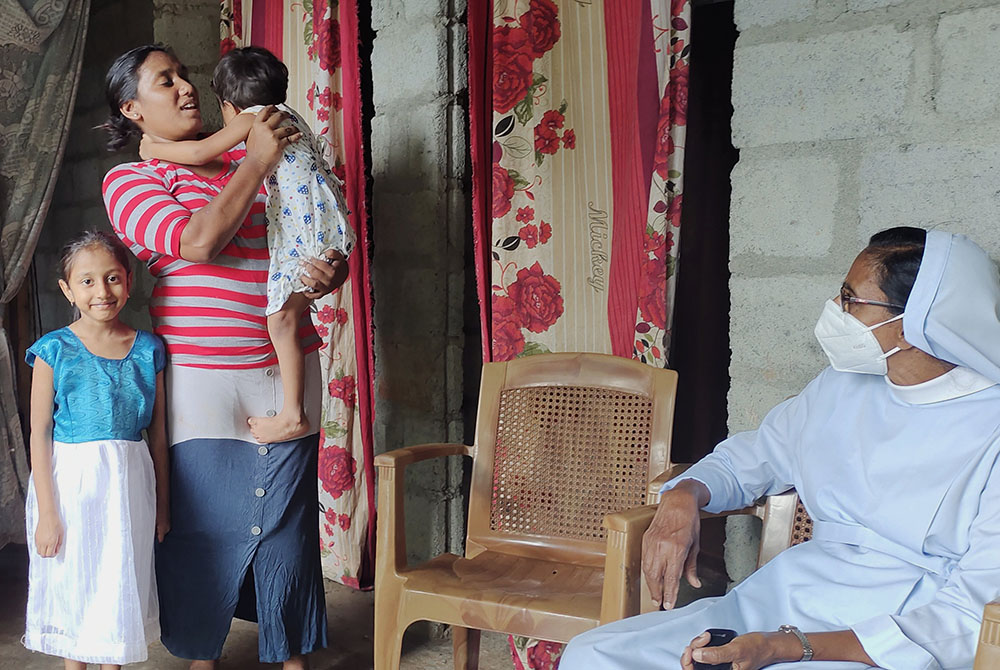 Sr. Dulcie Peiris, superior of a Salvatorian convent in Kurunegala, Sri Lanka, with Dilrukshi Fernando and her daughters. The nun was on a follow-up visit to Fernando's home, which was built by the Salvatorian Sisters with support from Share Global.