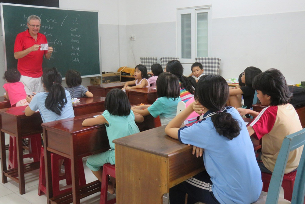 Philip MacLaurin teaches English for children at the Binh Trieu warm shelter run by the Friends for Street Children association, which serves children in poverty or in need. (Mary Nguyen Thi Phuong Lan)