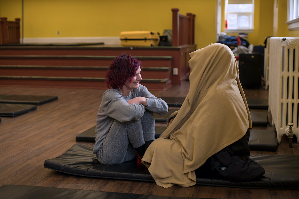 Pictured before the coronavirus pandemic, two guests talk at St. Felix Centre, a Felician-sponsored shelter in Toronto that offers a transitional home for women experiencing homelessness and also sponsors two 24-hour satellite "respite centers" all year. 