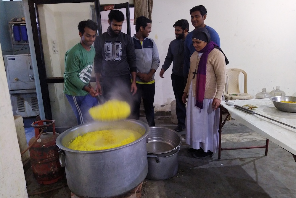 Seminarians and Sr. Preetha Varghese, a member of the Sisters of Imitation of Christ who is in charge of the Food for Hungry program, cook food at the cathedral hall to distribute to those who are in need. (Jessy Joseph)