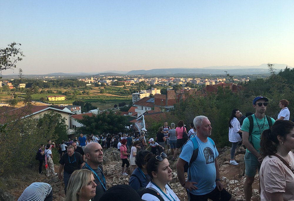 Pilgrims pray before a statue of Mary on Apparition Hill in Medjugorje, Bosnia-Herzegovina, in an August photo. (Kathryn Press)