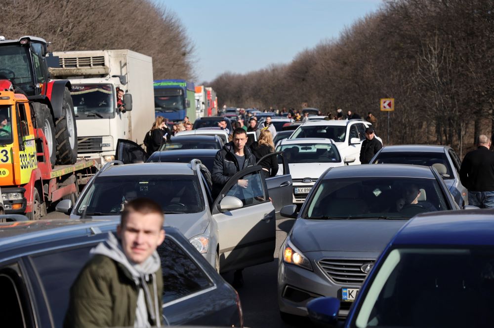 People wait in a traffic jam as they leave the city of Kharkiv, Ukraine, on Feb. 24 after Russian President Vladimir Putin authorized a military operation in Ukraine. (CNS/Reuters/Antonio Bronic)
