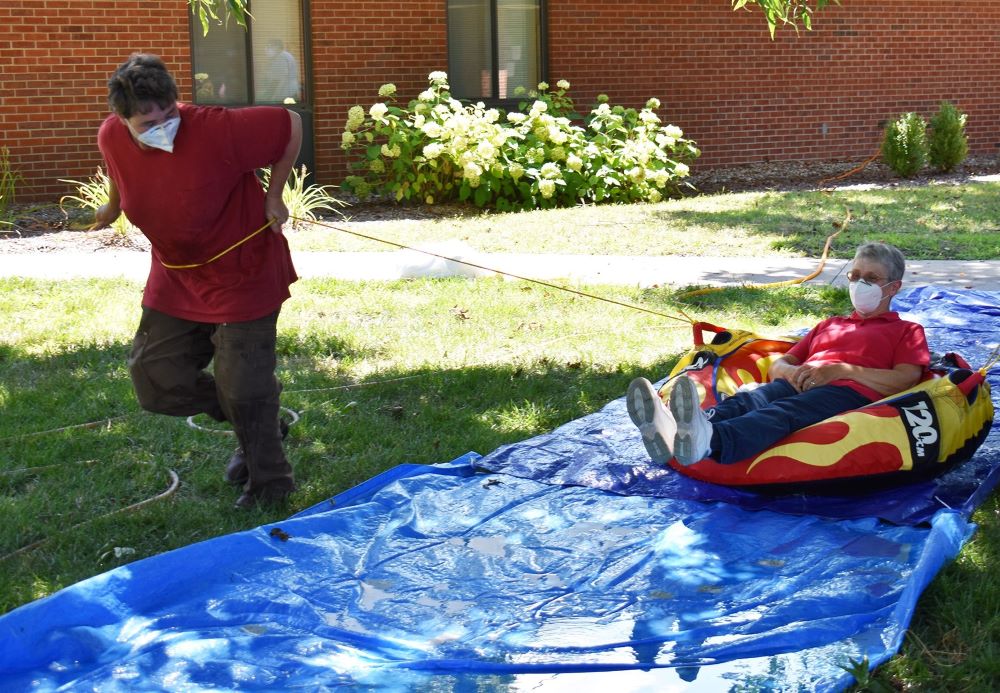 Sr. Elaine Fischer pulls Sr. Helen Mueting along a makeshift slip and slide for a bit of summer fun. (Julie A. Ferraro)