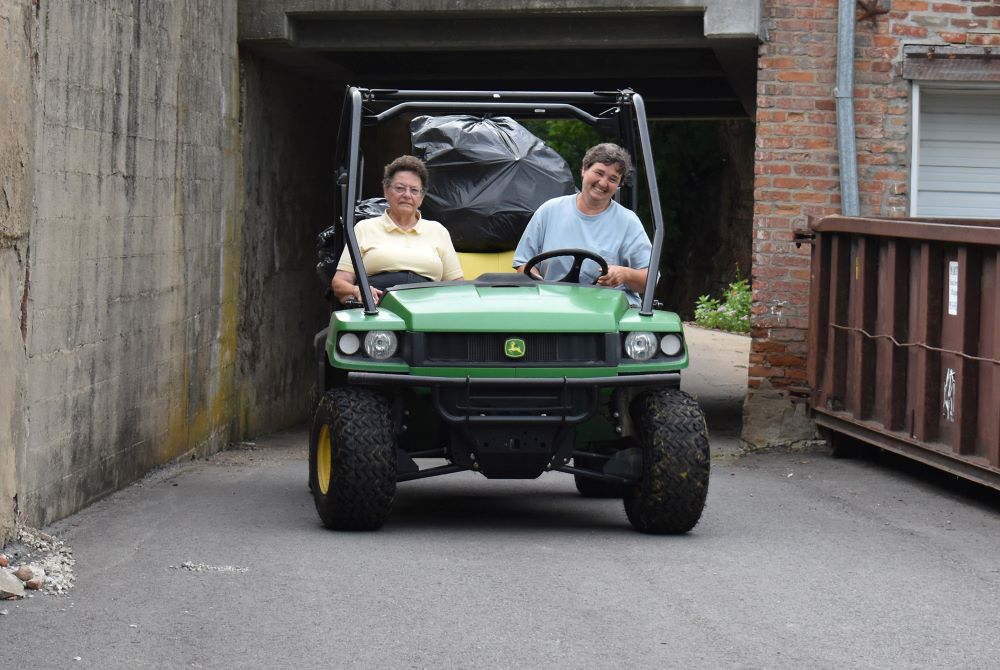 Sr. Elaine Fisher, with passenger Sr. Rosann Eckart, drives a load of trash to the Mount St. Scholastica dumpster. (Julie A. Ferraro)