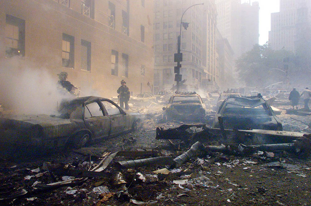 Cars smolder on a street in the Wall Street district after the World Trade Center in New York was hit by two hijacked airliners Sept. 11, 2001. (CNS/Reuters)