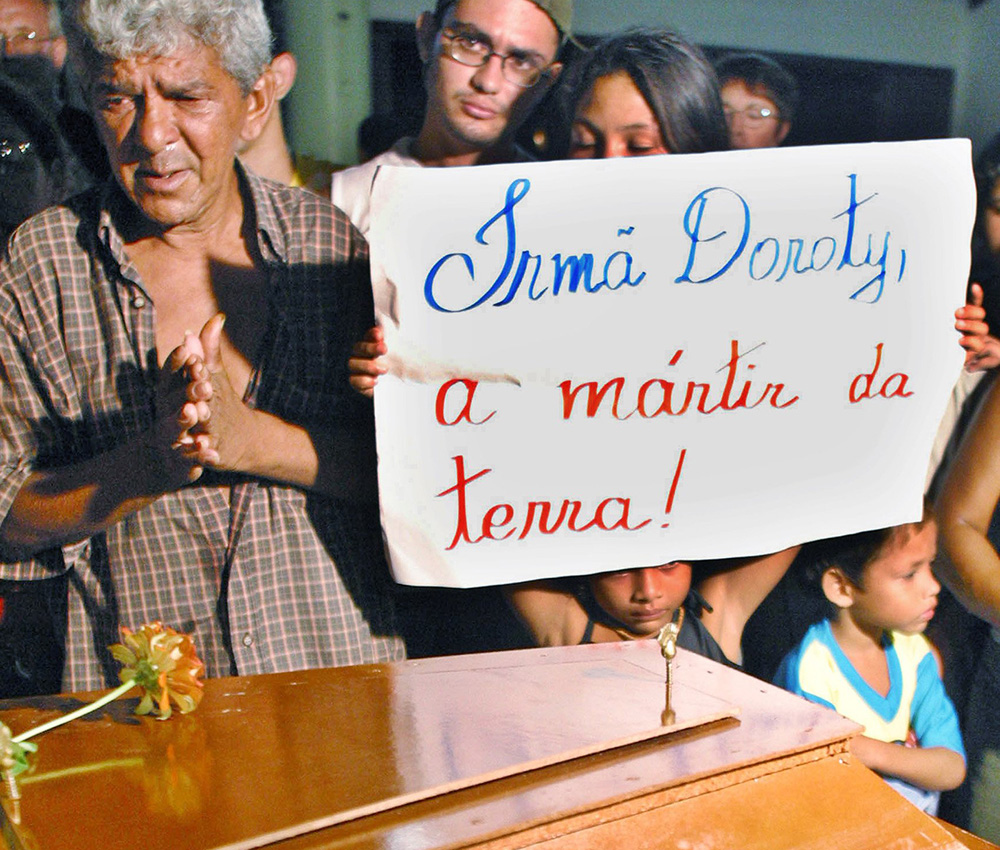 Brazilians mourn over the coffin of U.S. Sr. Dorothy Stang during a public wake Feb. 14, 2005, inside St. Maria Goretti Catholic Church in Belém, Brazil. The sign reads: "Sister Dorothy, the Earth's martyr." (CNS/Reuters)