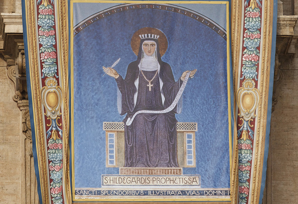 A tapestry showing 12th-century German abbess St. Hildegard of Bingen hangs from the facade of St. Peter's Basilica prior to the opening Mass of the Synod of Bishops for the new evangelization in St. Peter's Square Oct. 7, 2012, at the Vatican. (CNS)